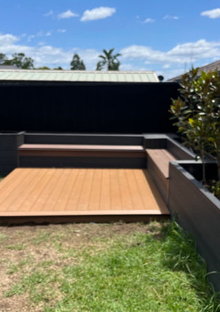 Outdoor deck with seating and surrounding greenery.