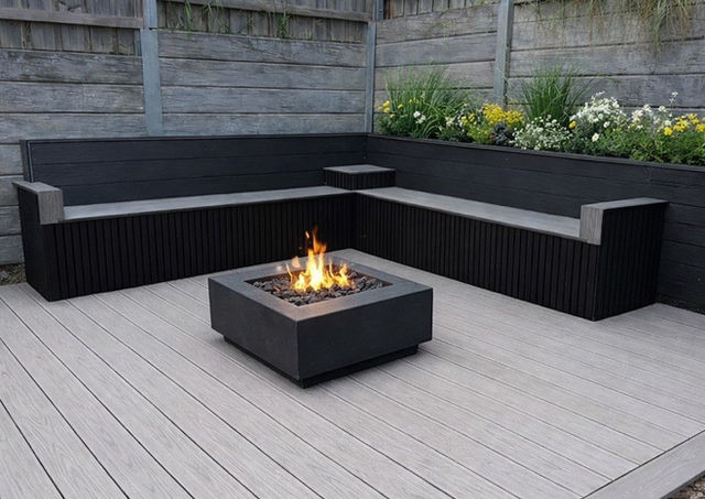 Modern patio with fire pit and corner seating.