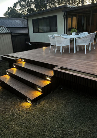 Outdoor deck with illuminated steps and dining set.