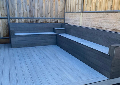 Gray outdoor deck with built-in bench seating.