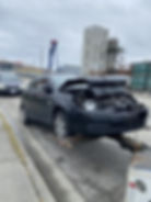Totalled car being put into flat box tow truck