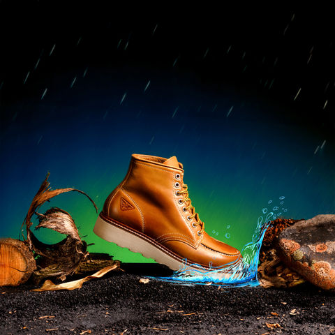 Scarpa outdoor in cuoio fotografata da Studio Bozzini Milano – fotografia still life di prodotto con effetto acqua e luce drammatica.