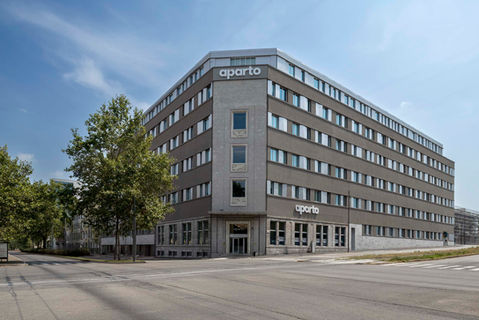 Edificio moderno Aparto a Milano, fotografia architettonica con luce naturale e prospettiva frontale, facciata razionalista in toni neutri e contesto urbano.