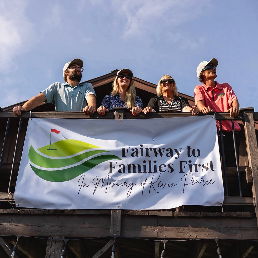 Four smiling adults on a balcony under a blue sky, holding a banner reading Fairway to Families First In Memory of Kevin Pearce