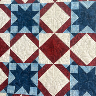 Red white and blue star block quilt set on point pieced by Breanna with 4th of July pantograph longarm quilting by High Rock Quilter.