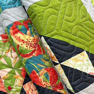 Robin Pickens Emilia quilt in Carolina Lilies fabric featuring Together pantograph longarm quilting by High Rock Quilter.