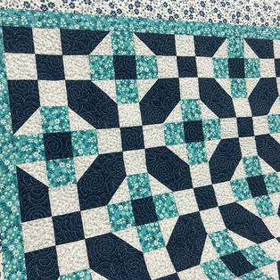 Blue Flowers in Blue quilt with Curly Twirly Flowers pantograph longarm quilting by High Rock Quilter.