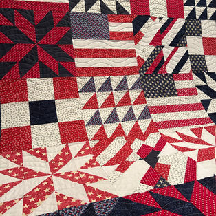 Red white and blue scrappy sampler Quilt of Valor pieced by Robin featuring Good Vibrations wave pantograph longarm quilting by High Rock Quilter.