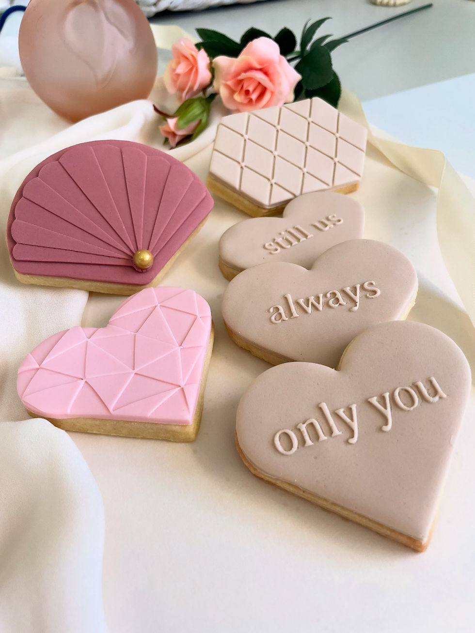 Heart cookies with embossed words in matte blush and nude tones.