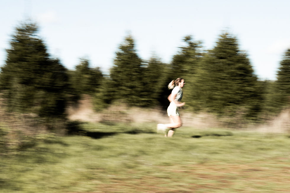 woman running through a fir tree forest with motion blur in the background