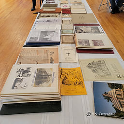 Historical books and documents of the history of Memorial Church of St. Luke laid out on a table for display purposes