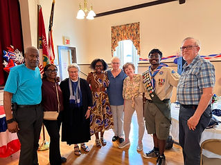 Two Boy Scouts standing arm in arm with Pastor Liz and leaders
