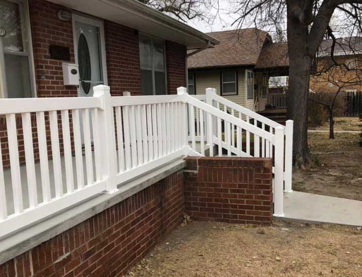White vinyl porch railing installed on a brick home entryway by G&H Worx