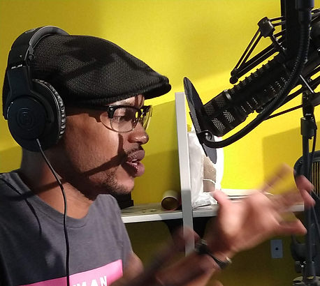A man speaks into a microphone while podcasting