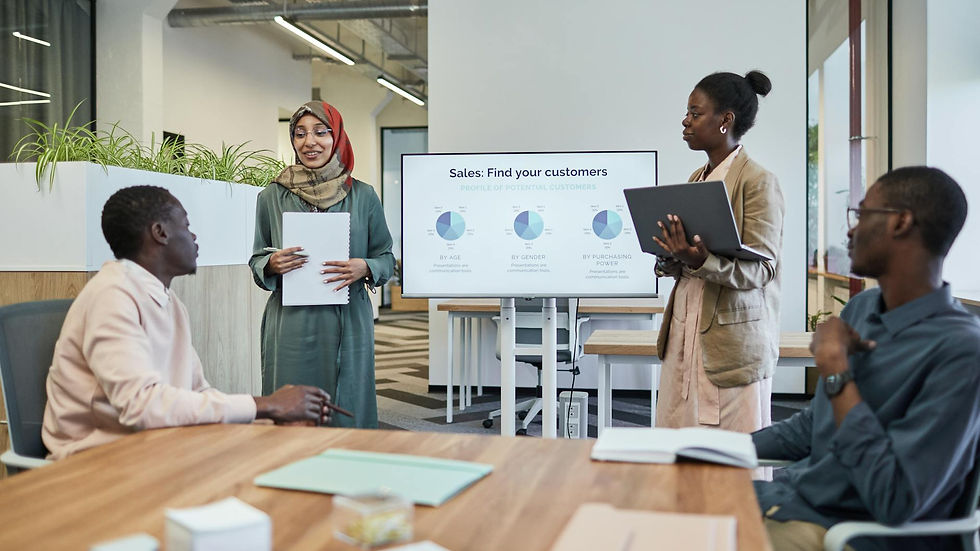 A diverse team discusses business strategy during an indoor presentation.