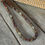 Thumbnail: a brown and red surfer necklace handmade with natural horn and bone beads