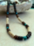 a surfer necklace for a man, beaded with cream carved bone, ebony wood, and turquoise stone
