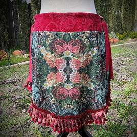 back view of a pirate wench skirt made of red and black floral cotton fabric has a coral chiffon and lace ruffle along a graduating hem