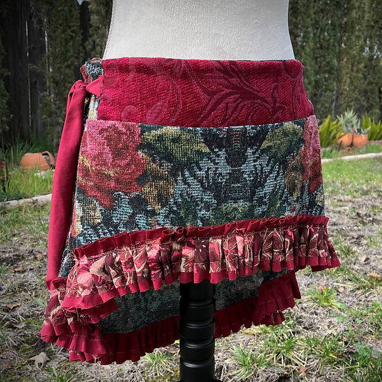 An upcycled skirt made of red and black floral cotton fabric has a pirate wench hem trimmed with a coral chiffon and lace ruffle