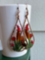 long glass bead earrings with a gold and orange flower garden wrapped inside copper wire teardrops