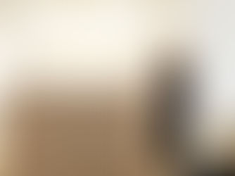 Kim Peters, Owner of Horizon Med Spa, leaning on the front desk of the med spa in black scrubs