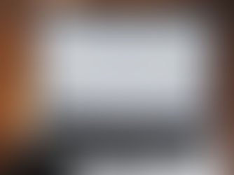 Laptop displaying Google homepage to discuss the difference between seo vs. aio on a wooden table, with a smartphone resting on the keyboard.