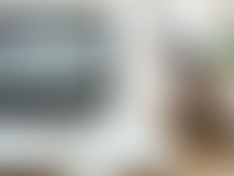 woman entrepreneur's desk with a coffee, an open laptop, and a pen writing a blog post for her SEO