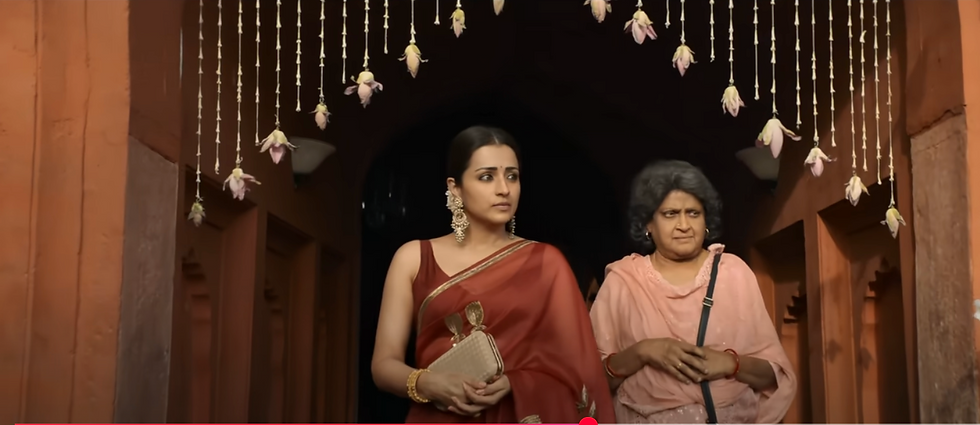 Trisha in a red saree walking into wedding scene in Thug Life in the Jingucha song
