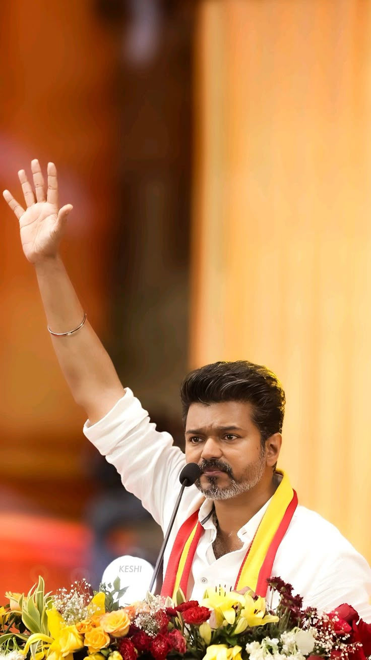 Actor Vijay, TVK Head, in white shirt and red scarf