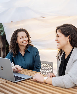 Allie & Stephanie working at a table with a laptop