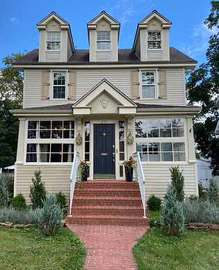 Exterior of a two story suburban home with brick pathway and stairs