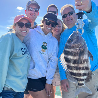 family fishing charter holding up a big sheepshead in sarasota fl