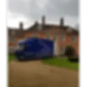 Blue removals van parked on the driveway of a large house