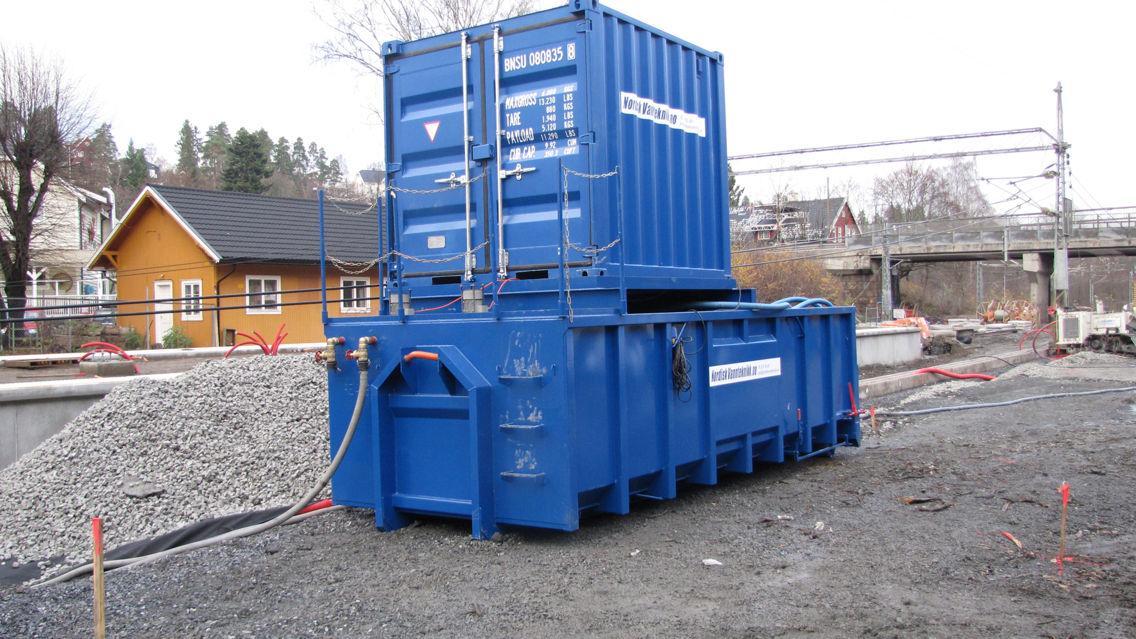 Mobilt renseanlegg som består av en sedimenteringscontainer med miksere og en styringscontainer med dosering