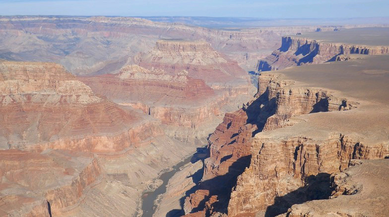 photo of the grand canyon from the canyon spirit helicopter tour, red rock formations in the grand canyon, aerial view of the grand canyon on a clear day, maverick helicopter tours