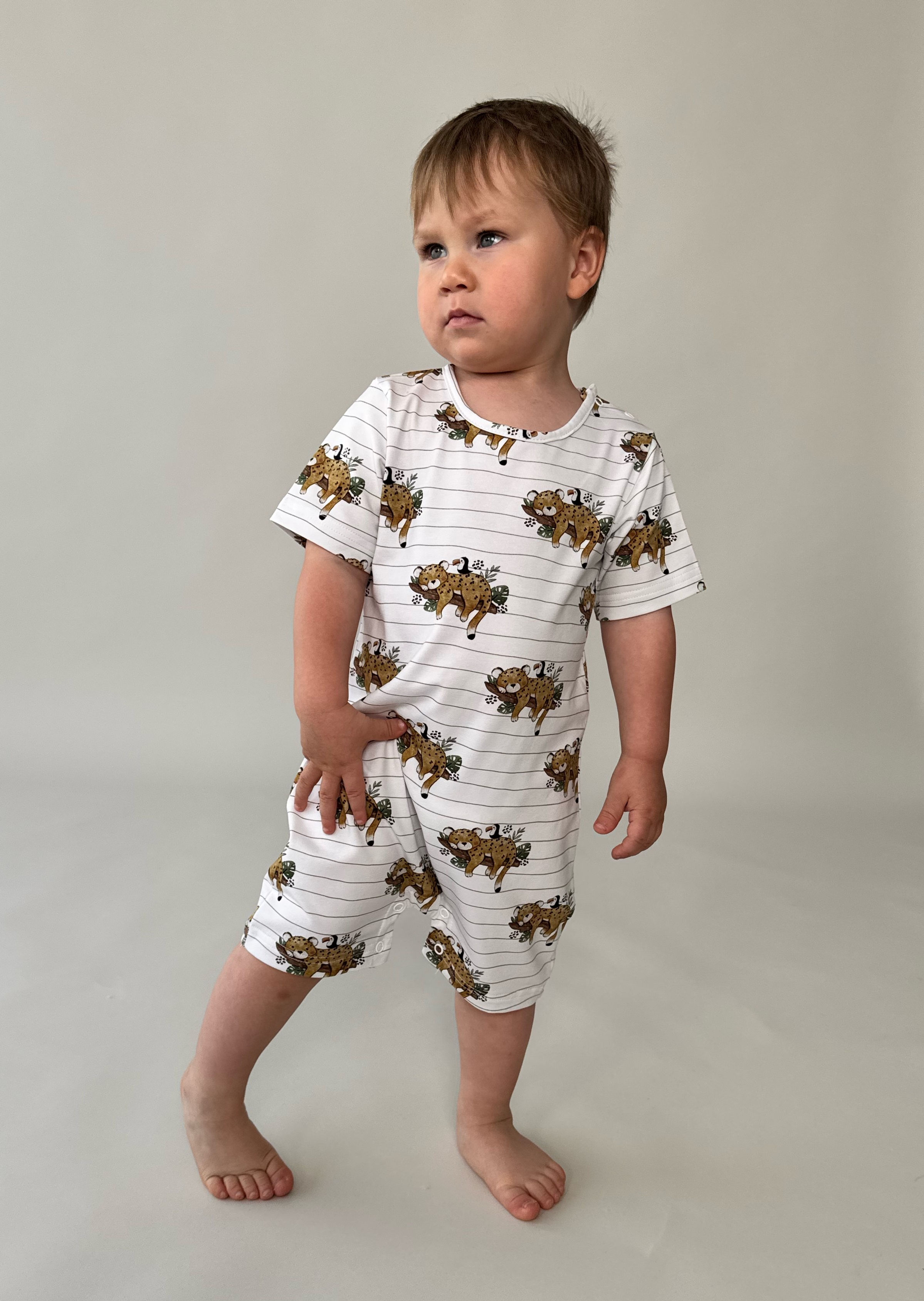 Baby standing and looking side wearing tiger summer baby romper