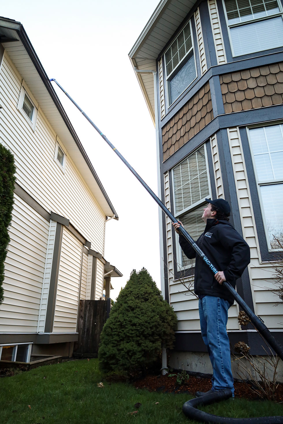 Willy's Window Washing crew member working along the roofline with an extension pole