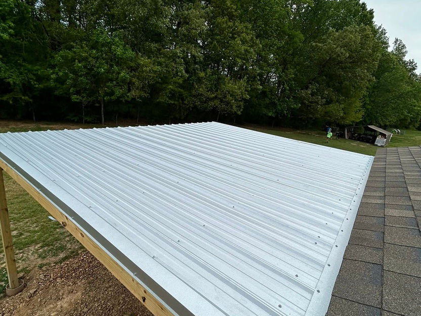 White corrugated metal roof under construction near trees