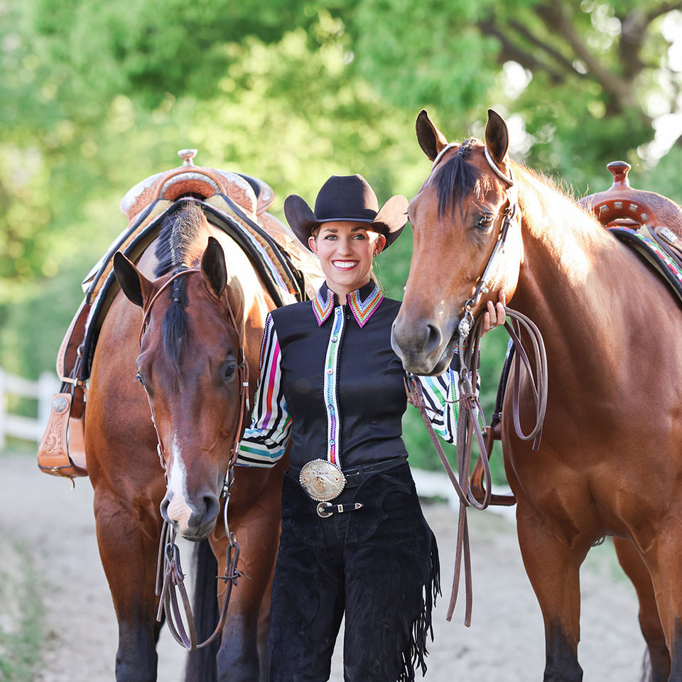 World Champion Lauren Stanley poses with her all-around geldings preparing for the horsemanship and a photoshoot. 