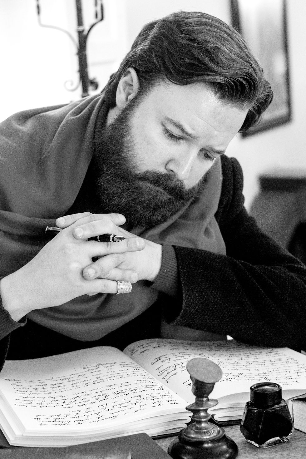 Michael Lieber at his desk, writing with fountin pen.
