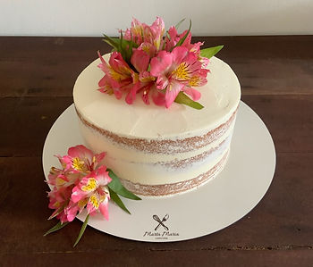 Naked cake artesanal com cobertura de buttercream branco e decoração de flores alstroemérias cor-de-rosa no topo e na base. Marta Maria Confeitaria Salvador.