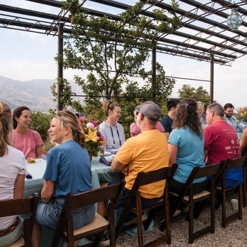 Attendees gathering around outdoor tables for tasting experiences on our private orchard in Santa Paula CA for members only