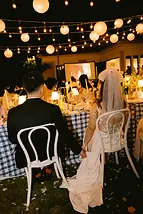 Khoảnh khắc yên bình của đôi tân hôn khi cùng ngồi cạnh nhau bên bàn tiệc dưới ánh đèn ấm áp