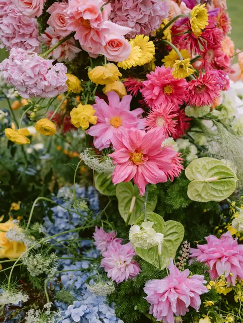 Close-up of vibrant flowers arranged for an outdoor wedding setting.