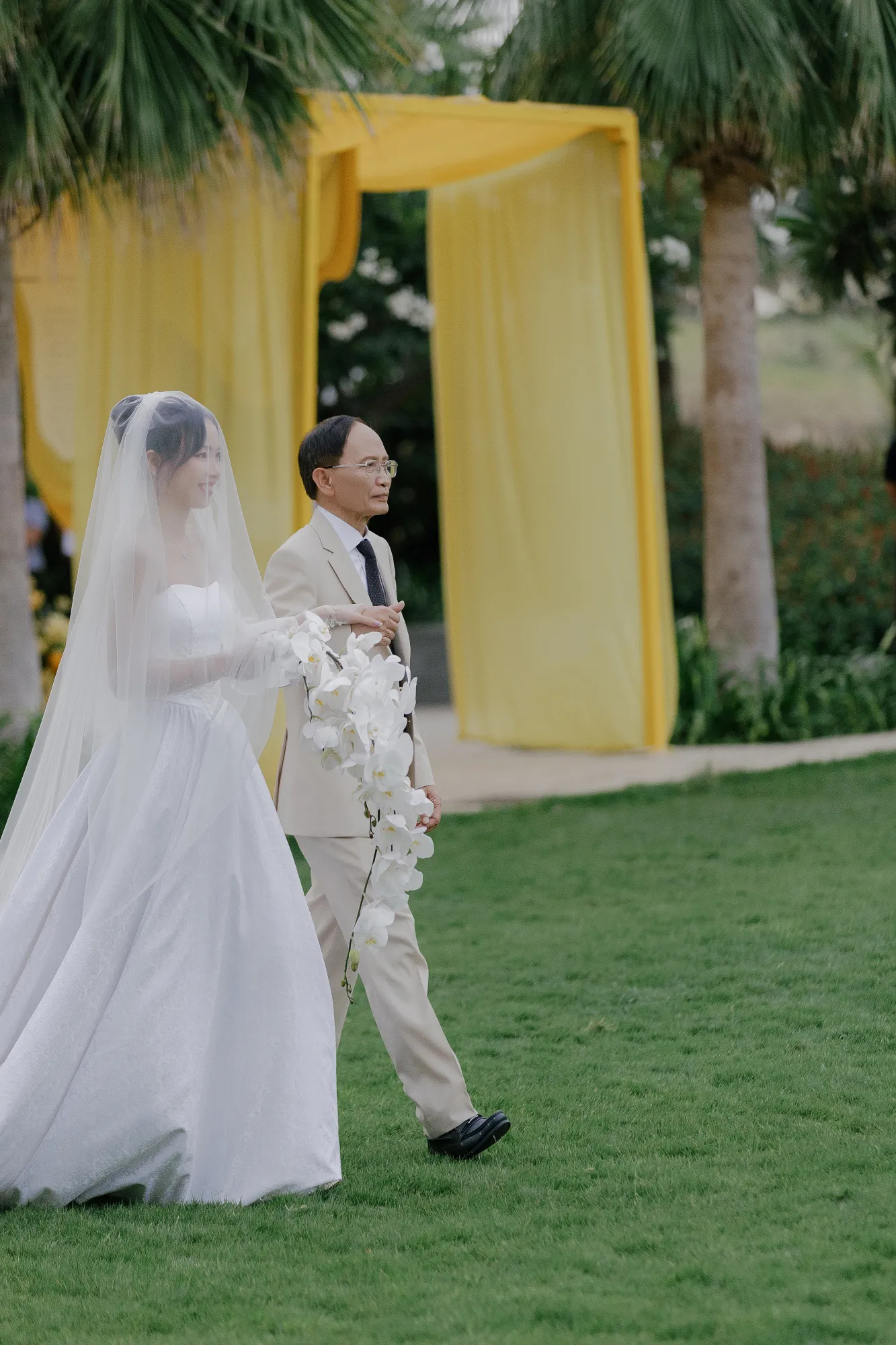 A father escorts the bride to the wedding ceremony.