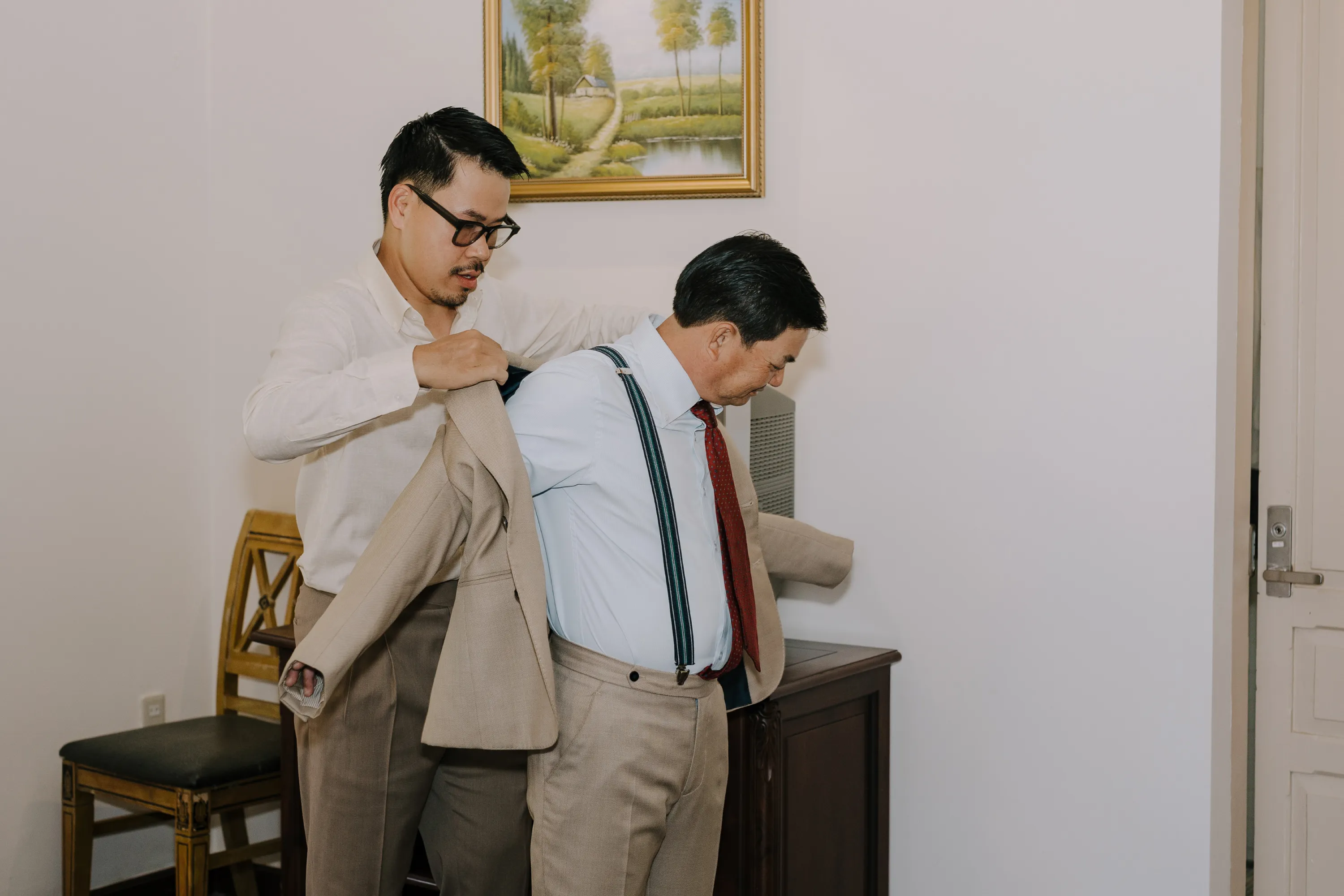 Chú rể giúp cha chỉnh áo vest trước buổi lễ.