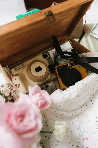 Vintage cameras arranged inside a wooden box as decorative wedding details.