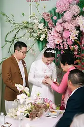 A family member presenting a ring to the bride during a traditional tea ceremony.