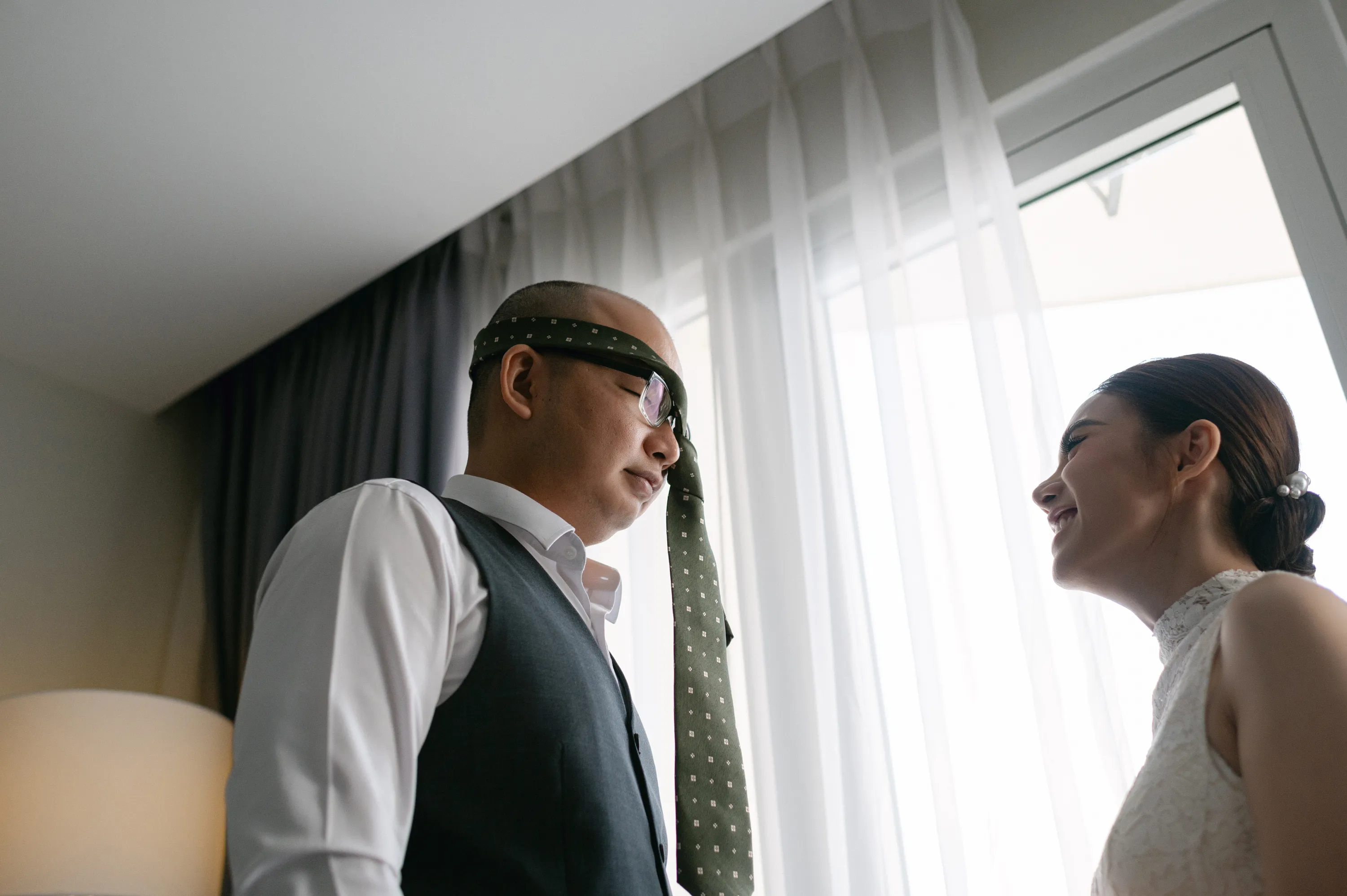 A playful moment between bride and groom while getting ready, filled with laughter and warmth.