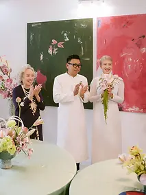 Family members applauding the bride and groom during a traditional wedding tea ceremony.